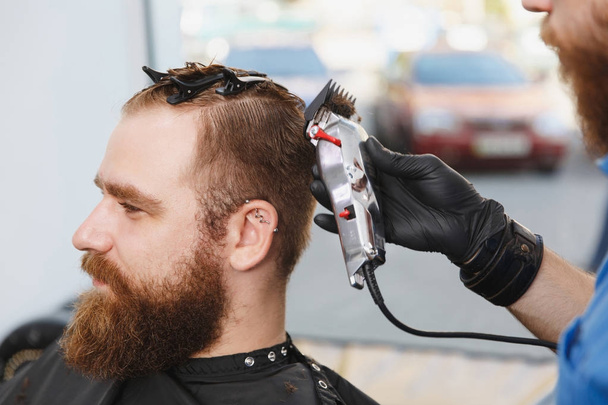 Close up van mannelijke professionele kapper client bedienen door clip - Foto, afbeelding