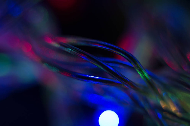 A colorful background with glowing Christmas garland wire. Macro shot. Selective focus. - Foto, Imagem
