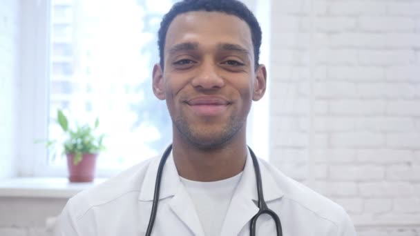 Sorridente felice afroamericano medico guardando fotocamera in clinica
 - Filmati, video