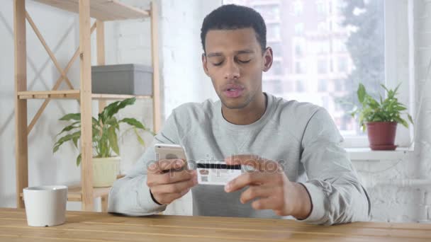 アフリカ系アメリカ人の男は、お支払いがスマート フォンにオンライン ショッピング - 映像、動画