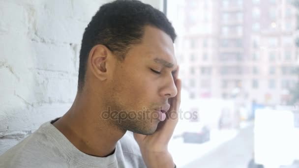 Az afro-amerikai fejfájás, ablakban fiatalember, aki közelről - Felvétel, videó