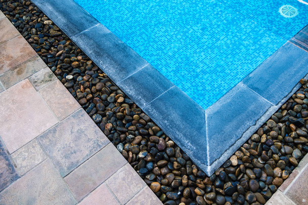 Edge of swimming pool with blue mosaic tiles at the bottom of th - 写真・画像