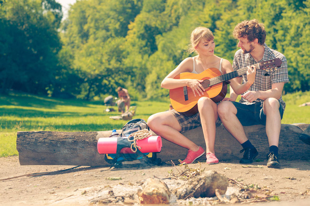 Young couple camping playing guitar outdoor - Zdjęcie, obraz
