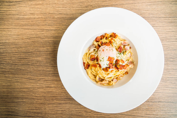 Spagetti carbonara tojással a tetején a fehér lemez - olasz élelmiszer-stílusban - Fotó, kép