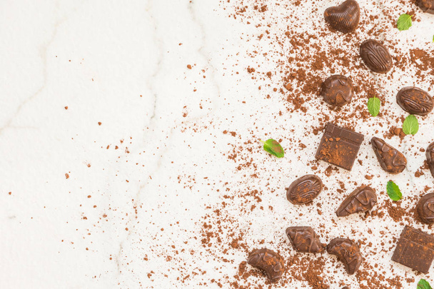 Γλυκό επιδόρπιο με κομμάτια μαύρης σοκολάτας και κακάο σκόνη σε άσπρο φόντο πέτρα - Φωτογραφία, εικόνα