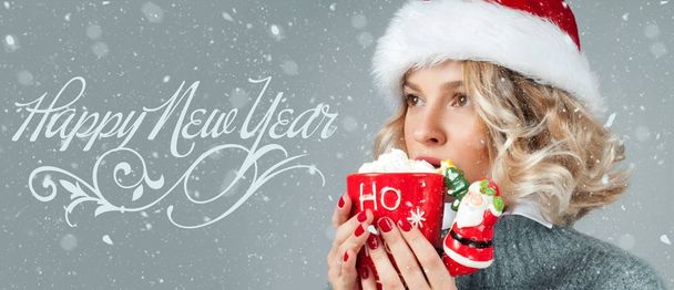 Woman in santa's hat is drinking coffee.  Happy  New Year - Foto, Imagen