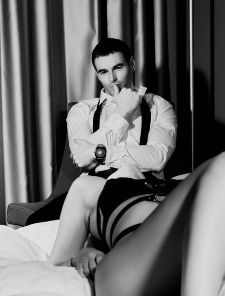 beautiful woman in underwear lying on a bed is trying to seduce a handsome guy - Φωτογραφία, εικόνα