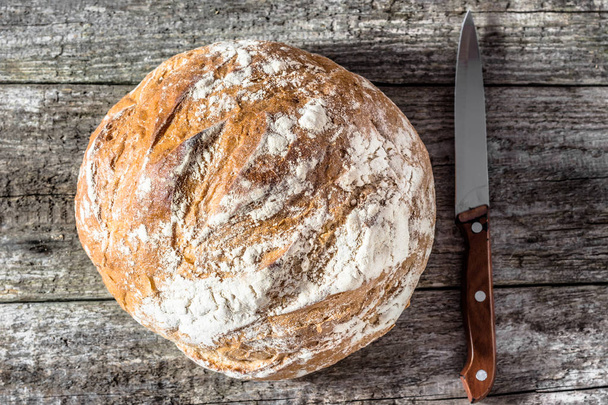 Fresh baked bread loaf on rustic wooden table, baking concept - Fotoğraf, Görsel