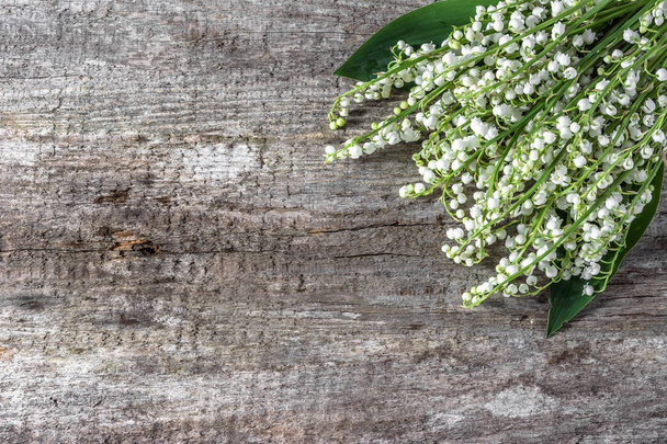 Fiori freschi di primavera, bouquet di lilly della valle su sfondo di legno utile come biglietto di giorno di madri
 - Foto, immagini