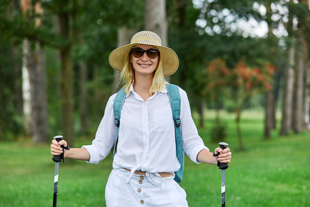 young woman with nordic walk pols - Foto, Imagen