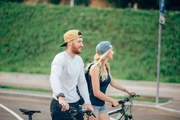 mężczyzna i kobieta chodzić swoje rowery w dół drogi - Zdjęcie, obraz