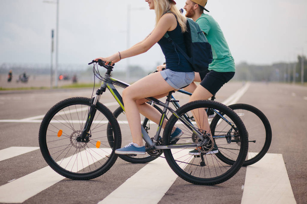 Side view of a middle aged man and woman biking road - Foto, afbeelding