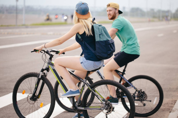 Side view of a young couple on cycle ride in countryside - Foto, afbeelding