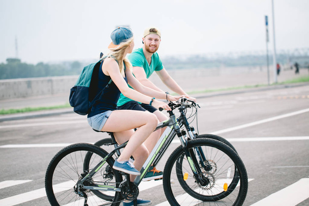 Active couple on a bike ride in the countryside on a sunny day - Foto, imagen