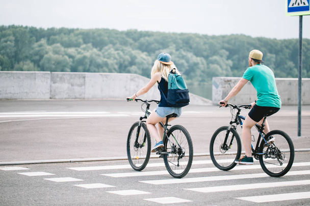 Young sporty couple riding on bicycle. Rear view. - Valokuva, kuva