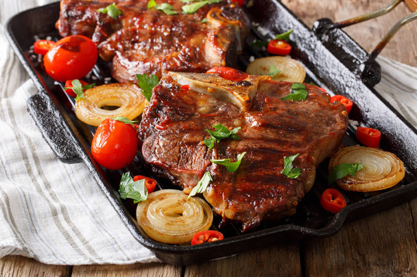 Delicious food: T-Bone steak with tomatoes, chili and onions in  - Photo, Image