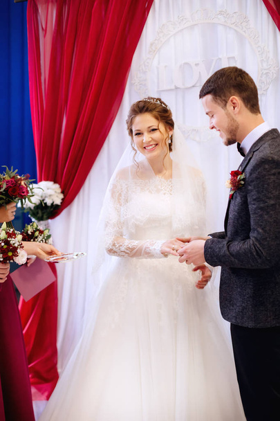 искренняя улыбка молодой невесты, которая стоит рядом со своей возлюбленной
 - Фото, изображение