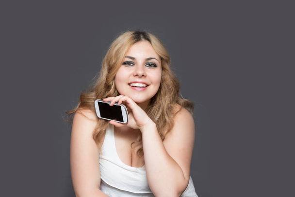 Long haired woman showing smart phone at the camera - Photo, Image