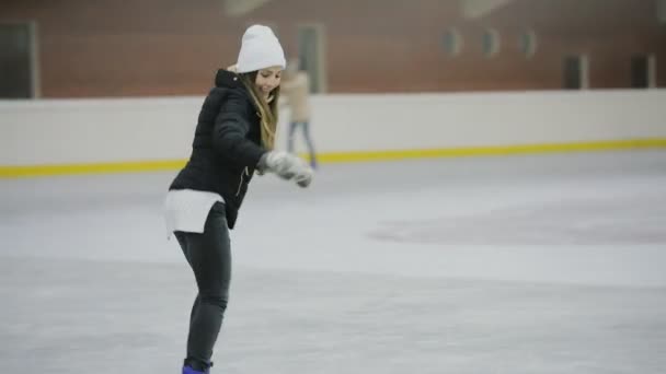 Mulher feliz patinando em uma pista de gelo, férias de inverno
 - Filmagem, Vídeo