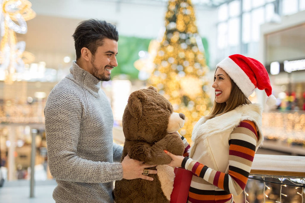 Красивая пара в торговом центре на Рождество с Тедди Б
 - Фото, изображение