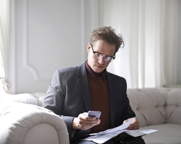 Elegant man with smartphone and paper  - Photo, Image