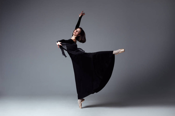 Slim ballerina in a black long dress - Foto, Imagen