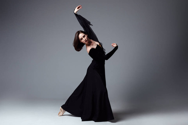 Slim ballerina in a black long dress - Fotó, kép