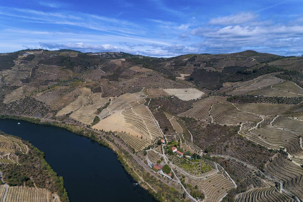 Εναέρια άποψη του ποταμού Douro και τις γύρω πλαγιές με πεζούλες και ένα κτήμα οινοποιίας στην Πορτογαλία, Ευρώπη. Ιδέα για το ταξίδι στην Πορτογαλία και στην περιοχή Douro - Φωτογραφία, εικόνα