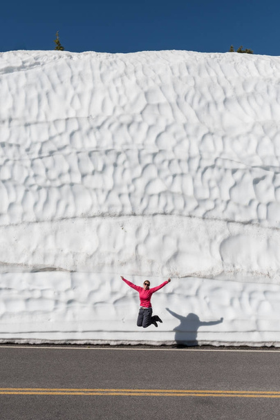 Femme saute devant la grande dérive de neige
 - Photo, image
