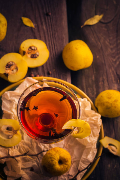 Tincture cup fruit quince wooden table - Foto, afbeelding