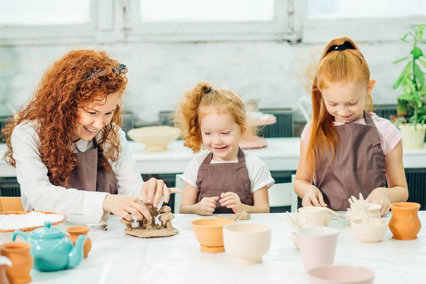 redhead Mother and kid daughter at home molded from clay and play together - Foto, Imagen
