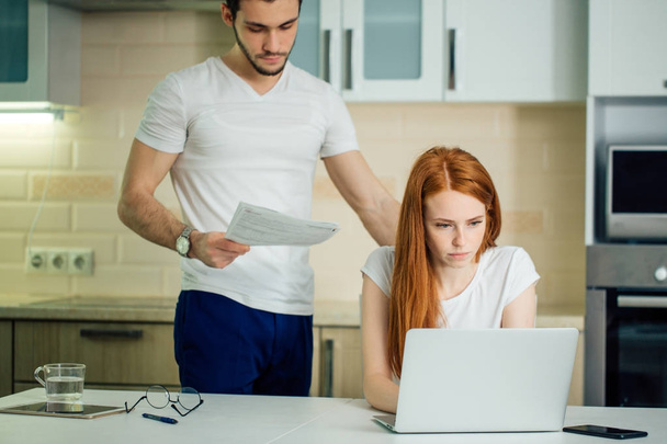 couple at home paying bills with laptop - Foto, afbeelding