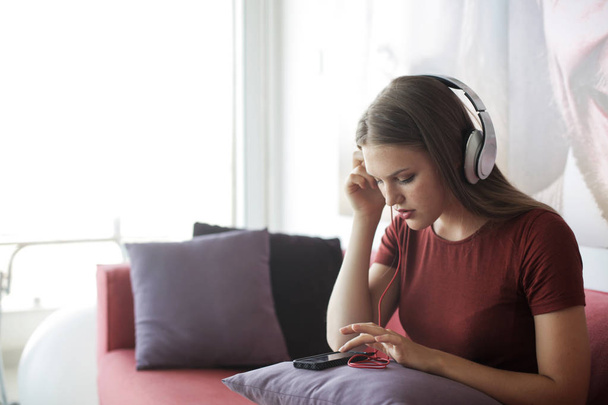 Woman listening to music from her phone with headphones - Foto, Imagen