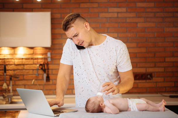 Man working from home and taking care of baby - Foto, immagini