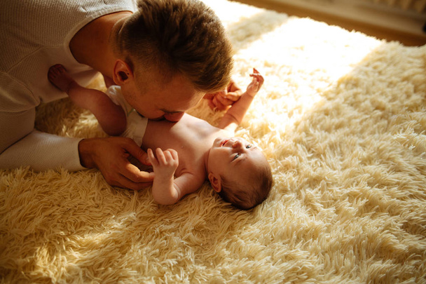 father playing with adorable baby in bedroom - Photo, image