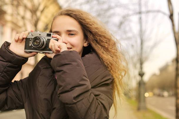Girl with curly hair using an anagogic camera outdoor - Foto, imagen