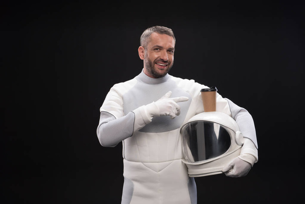 Cheerful pleasant astronaut is posing with espresso - Photo, image