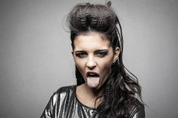 Mujer joven con un peinado elaborado que hace una expresión asquerosa
 - Foto, Imagen