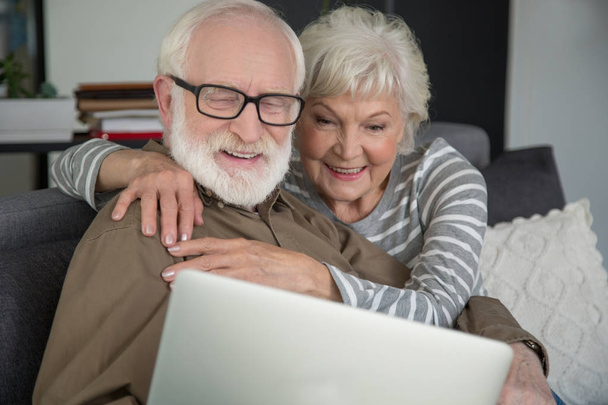 Married mature husband and wife relaxing with laptop - Foto, afbeelding