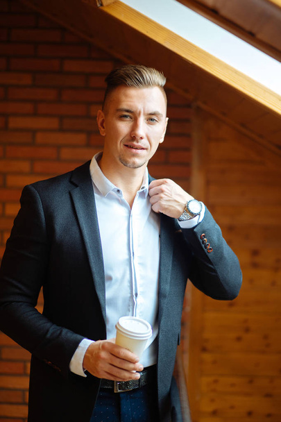 handsome businessman drinking coffee in home and looking away - Фото, зображення