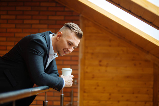 handsome businessman drinking coffee in home and looking away - Fotoğraf, Görsel