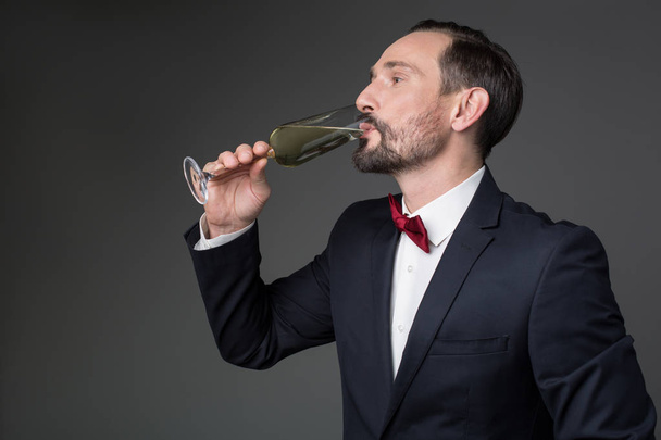 Elegant bearded businessman drinking champagne - Фото, изображение