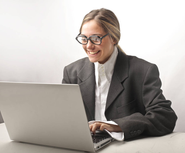 Businesswoman with glasses and laptop laughing - Фото, зображення