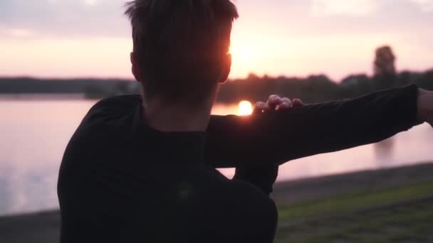 Hidasliikkeinen vapaa mies harrastamassa auringonnousua. Takaisin näkymä mies keinuvat kädet kaunis aamu vesi panoraama
. - Materiaali, video