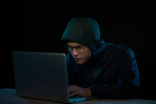 ノート パソコンの前に座ってフーディ暗闇の中のハッカー。コンピューター プライバシー攻撃 - 写真・画像