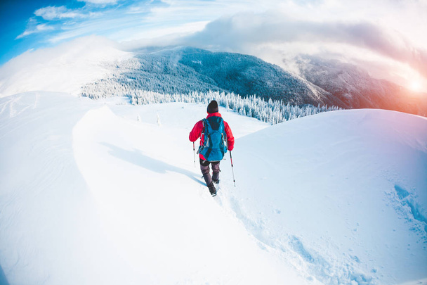 Ένας άνθρωπος με χιονοπέδιλα στα βουνά το χειμώνα.  - Φωτογραφία, εικόνα