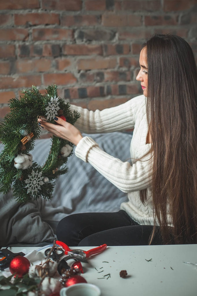 Молодая женщина изготавливает рождественские украшения дома
 - Фото, изображение