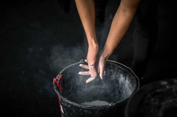 woman rubs his hands with chalk and talc so that fingers do not slip or slide - Foto, imagen