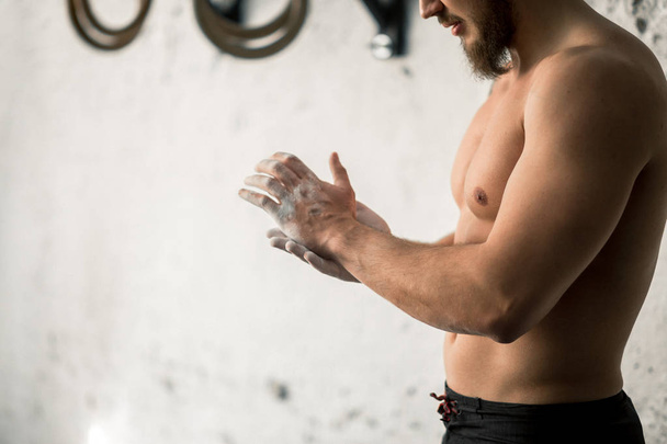 Athlete clapping hands with talc before deadlift barbells workout - Photo, image