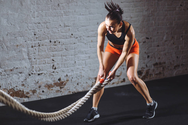 Battle ropes session. Attractive young fit and toned sportswoman training in gym - Φωτογραφία, εικόνα
